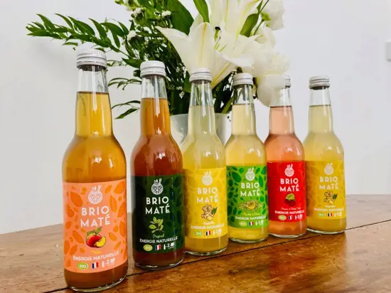 Photo de la gamme de bouteilles Brio Maté sur une table en bois